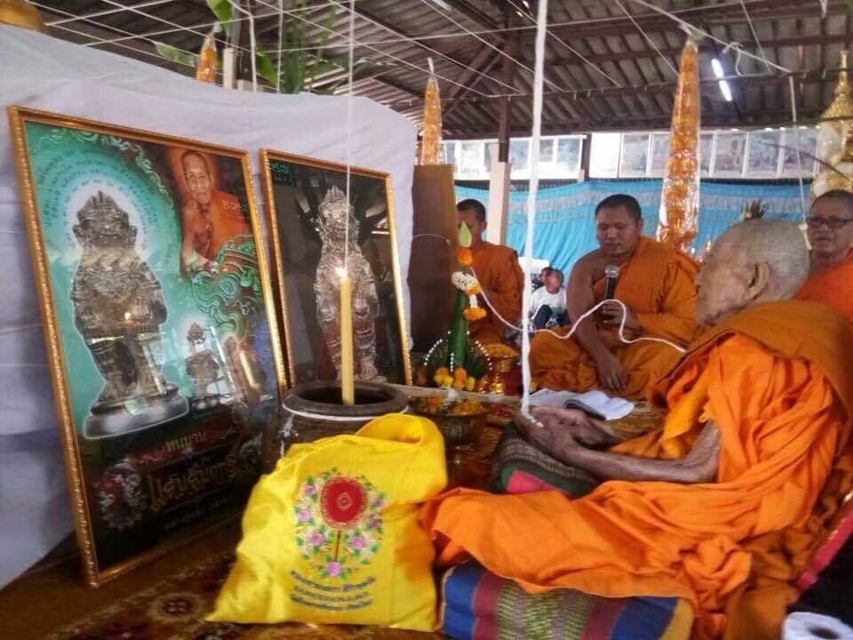 Thai Buddhist monks blessing Hanuman Saensamrit Amulet . framed amulets candle and offering bag at a ceremony