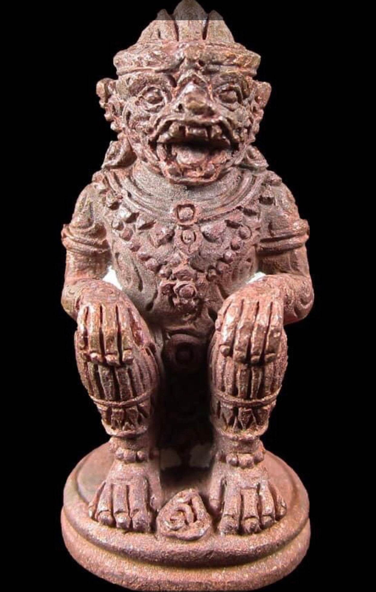 Hanuman Saensamrit Amulet . Small reddish brown seated Hanuman amulet with carved details on round base