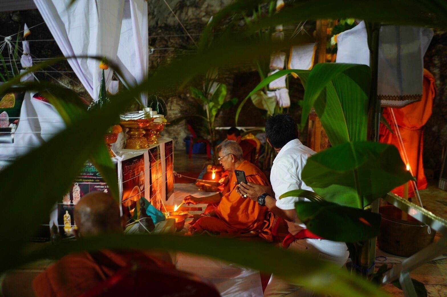 Monks performing a traditional ceremony with Thai herb blessing oil in a decorated setting