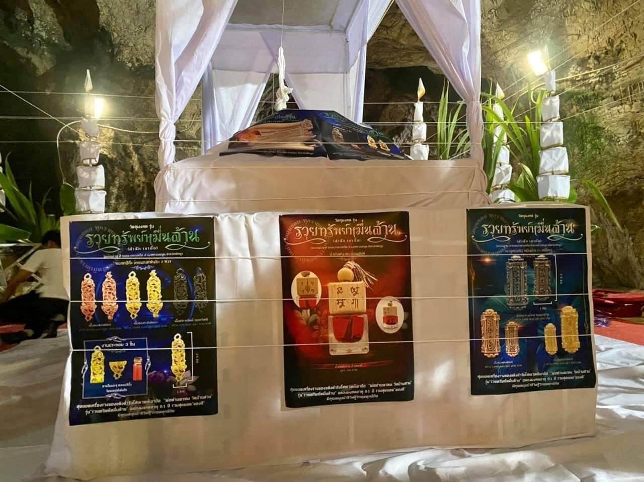 Thai herb blessing oil display with traditional Thai spiritual items and informational posters in a decorated setting
