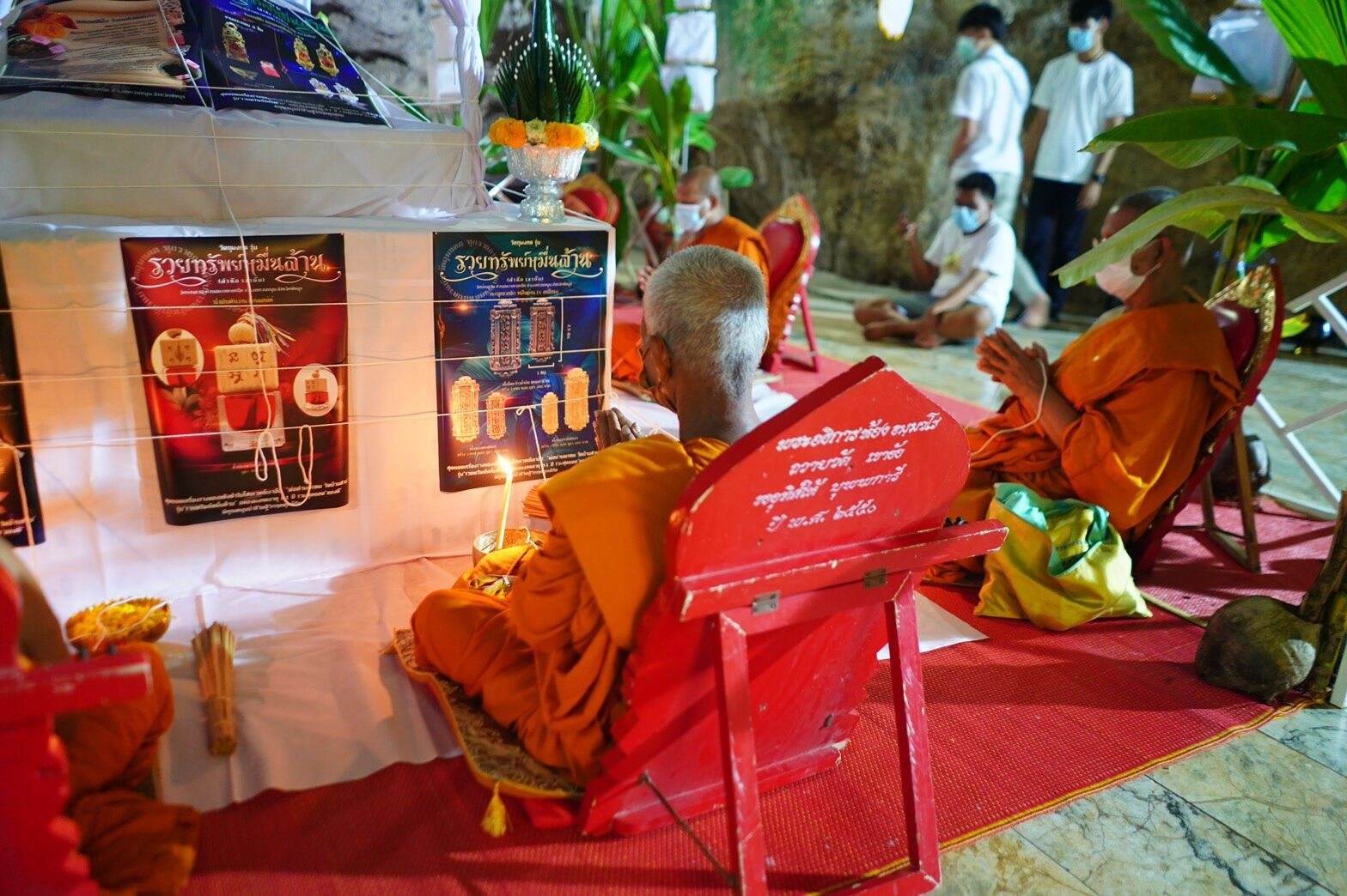 Thai monks performing a blessing ritual with Thai herb blessing oil in a temple setting