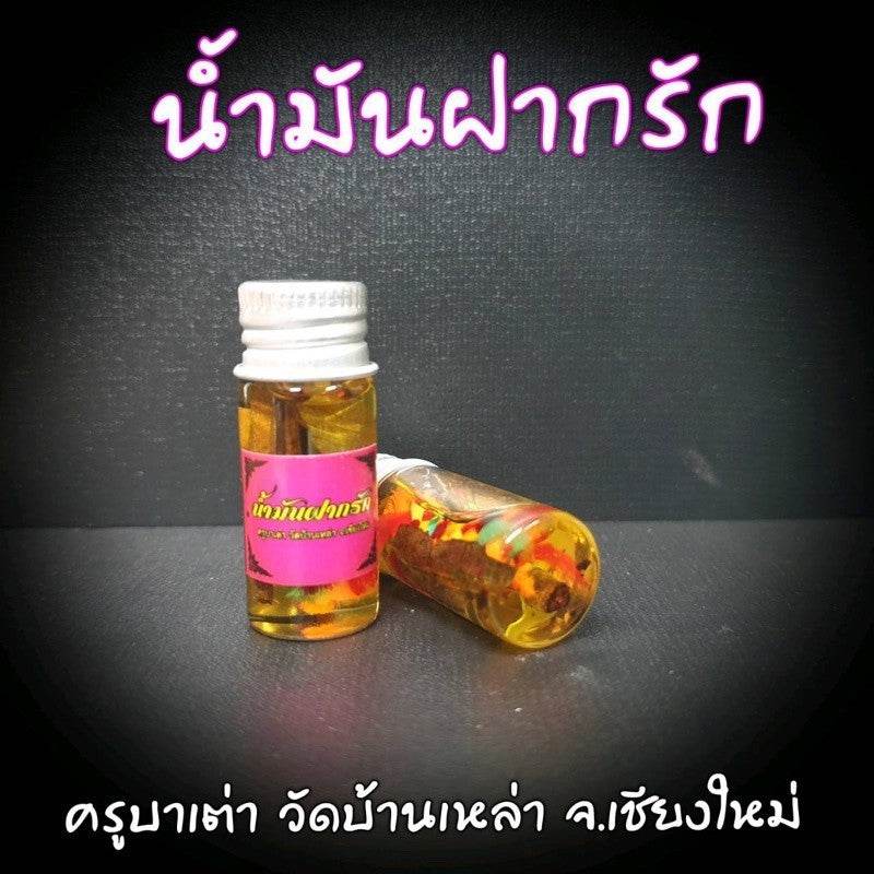 Thai love oil amulet in a small bottle featuring vibrant herbs for attracting love and positive energy