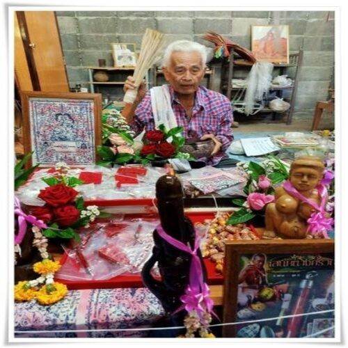 Thai love talisman cloth displayed with offerings and a spiritual practitioner in a serene setting