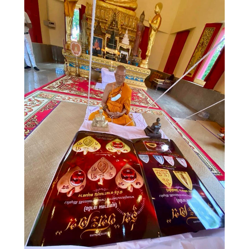 Thai luck amulet for victory displayed in a temple with a monk seated in the background