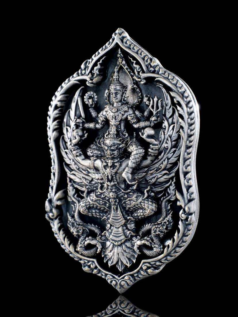 Intricate silver Thai lucky coin for wealth and protection featuring detailed designs and auspicious symbols