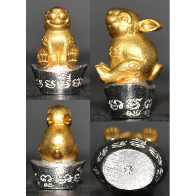 Thai Lucky Rabbit Amulet - Limited Edition Golden Wealth Charm for Prosperity 2k sits on a pile of money