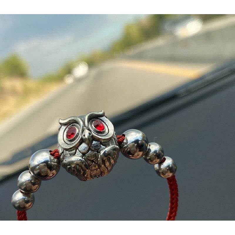 Thai owl charm for luck and prosperity on a red cord bracelet with metal beads
