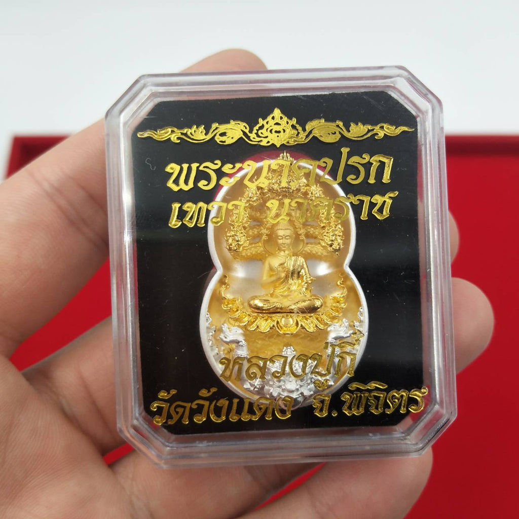 Handheld clear case with gold Phra Nak Prok amulet for protection on black backing showing Thai script
