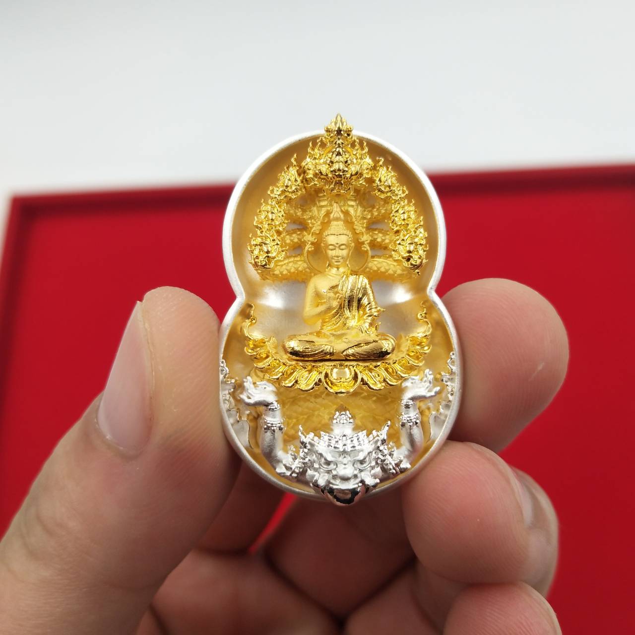 Phra Nak Prok amulet for protection gold and silver detailed miniature Buddha pendant held in hand