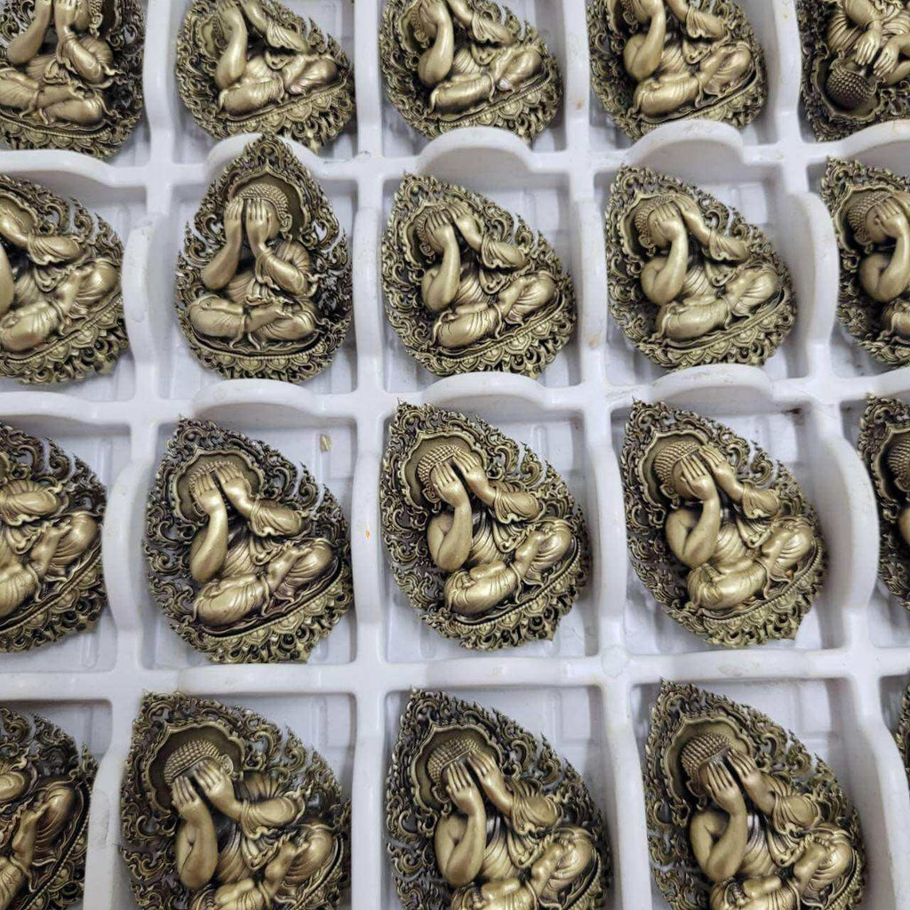 Collection of Thai Phra Pidta amulets for protection with intricate designs in gold finish