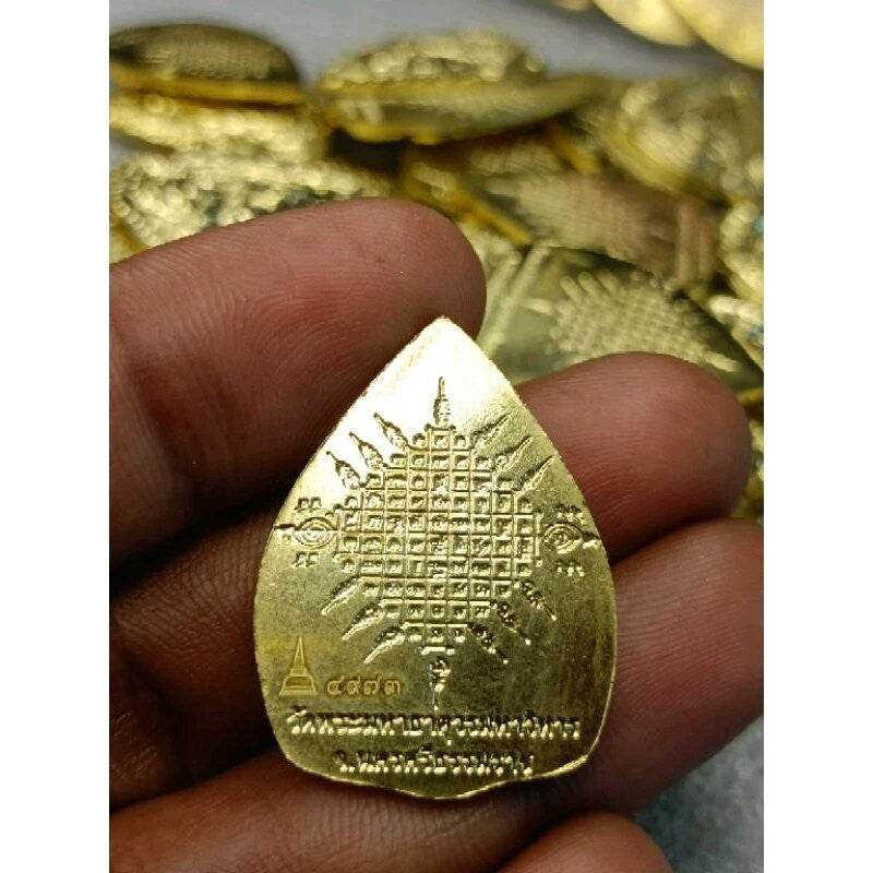 Handheld gold Phra Rahu protection amulet with engraved yantra grid and Thai script for protection and luck