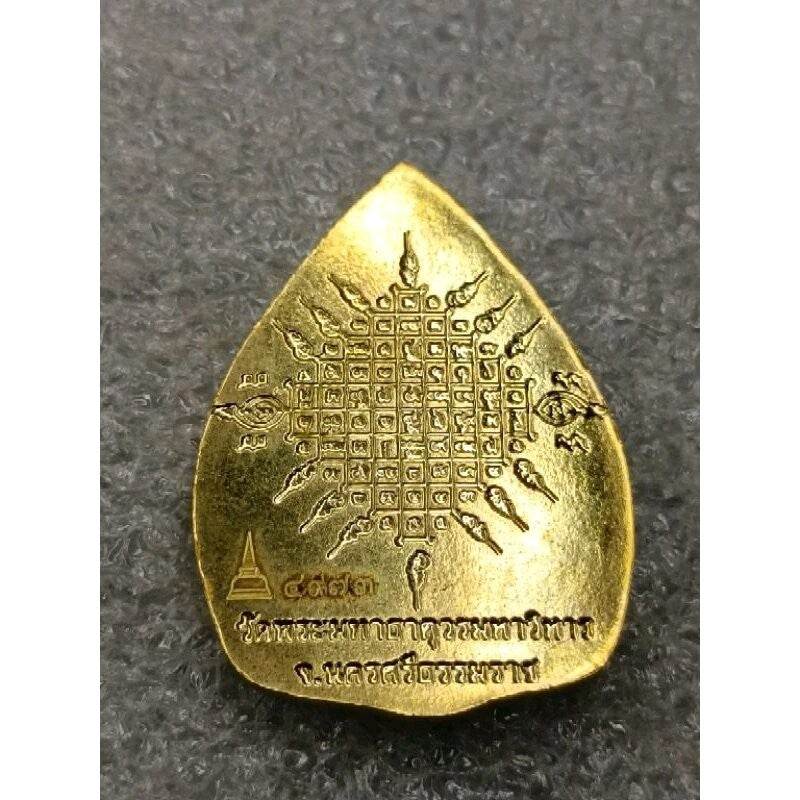 Gold Phra Rahu protection amulet teardrop with engraved yantra grid and Thai script for spiritual protection