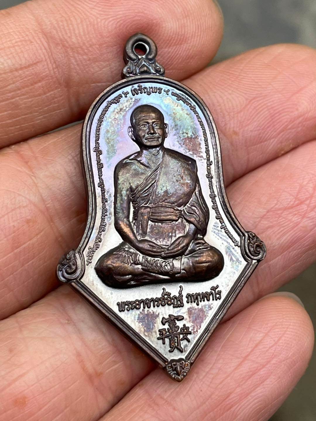 Thai prosperity amulet for sale featuring a seated monk in intricate design and detailed craftsmanship