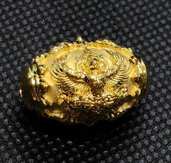 Gold Thai protection amulet for prosperity featuring intricate design and mythical creature detail