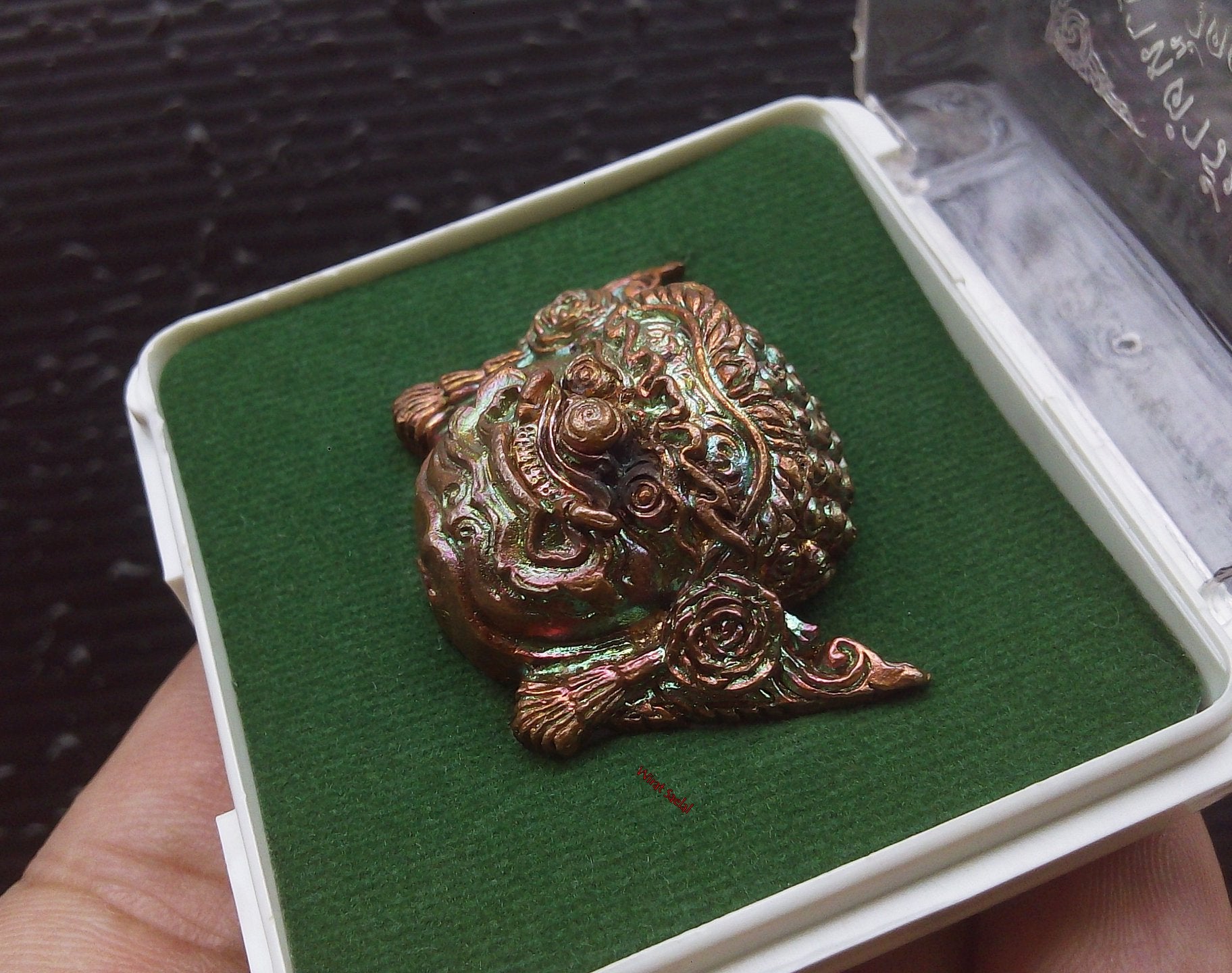 Thai protection amulet Rahu by Thai Blessing Co displayed in a protective case with green felt lining