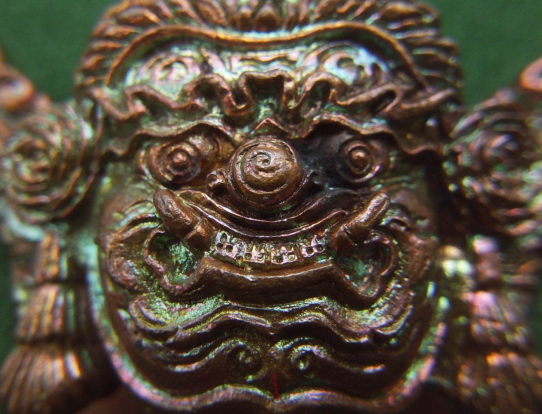 Close-up of a Thai protection amulet Rahu featuring intricate details and a colorful finish