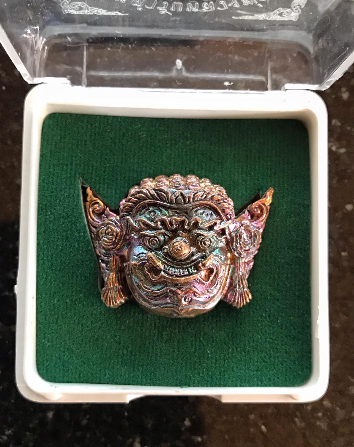 Colorful Thai protection amulet Rahu in display case, depicting intricate details and craftsmanship