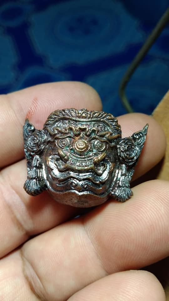 Intricate Thai protection amulet Rahu in silver design held in a hand for spiritual protection