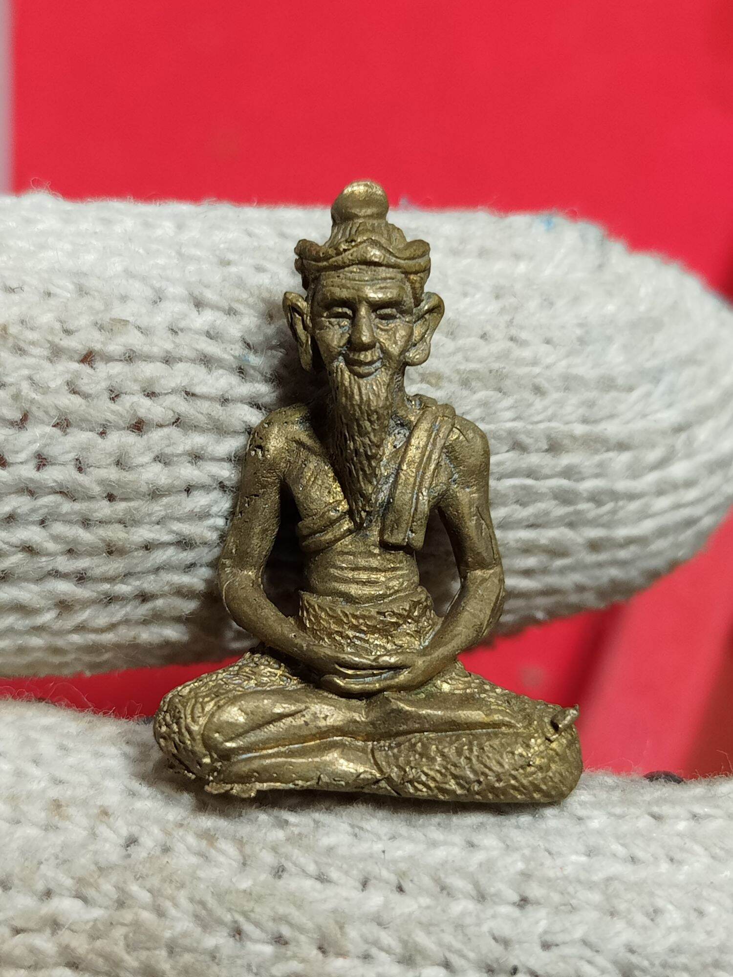 Small brass Ruesi Hermit Amulet Wat Khao Or pendant showing seated bearded hermit in meditation