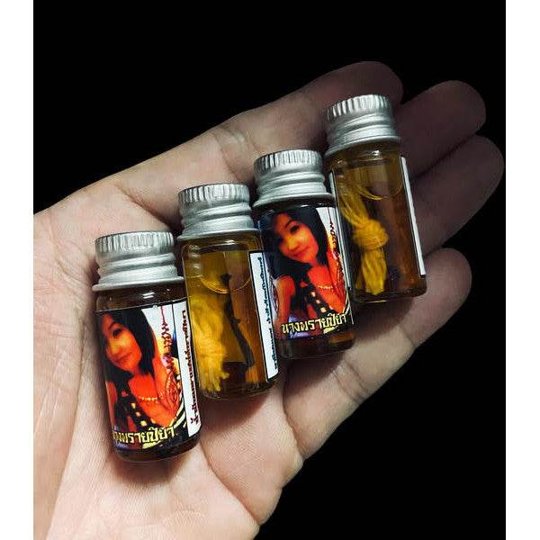 Four bottles of Thai seduction oil for attraction in a hand, featuring alluring packaging
