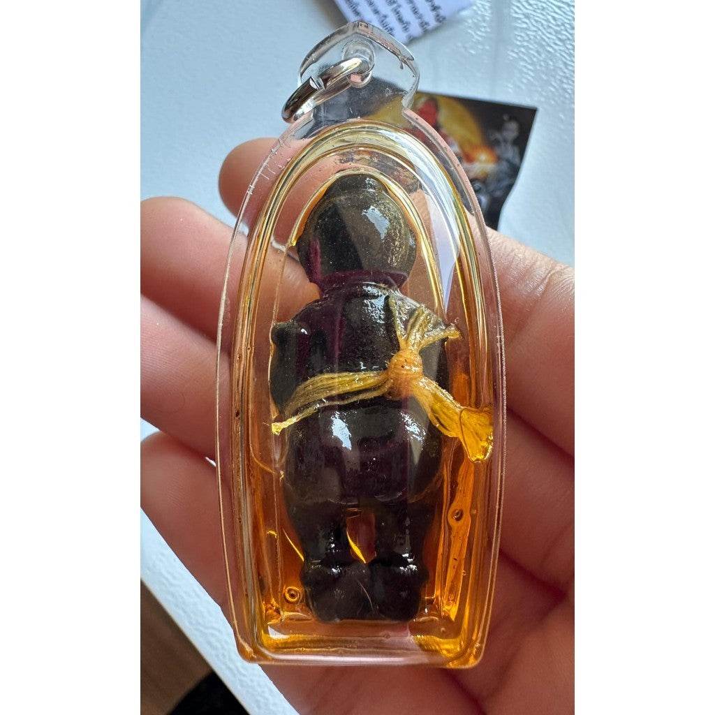 Thai spirit doll for wealth and protection encased in a clear protective casing, held in hand