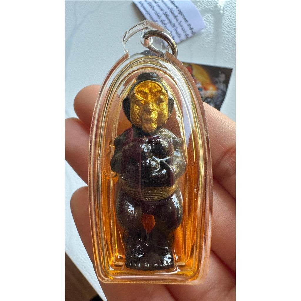 Thai spirit doll for wealth and protection encased in a clear charm, showcasing intricate details and vibrant colors