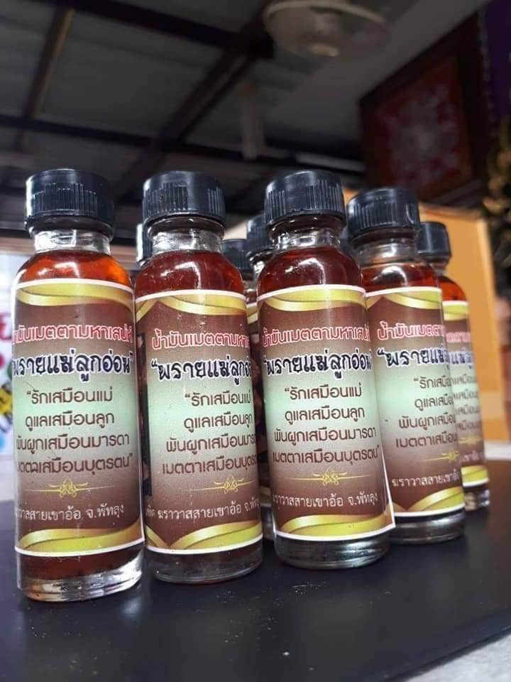 Thai spiritual wealth amulet oil bottles from Thai Blessing Co arranged in a row with brown labels