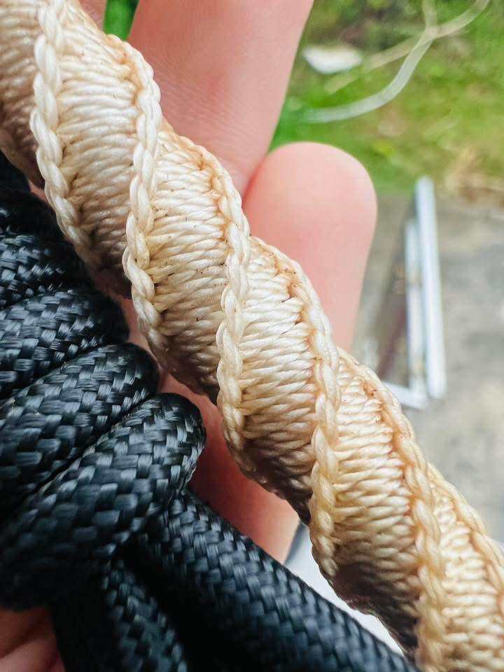 Close up of braided beige and black cords Takrud waist amulet for protection from Thai Blessing Co