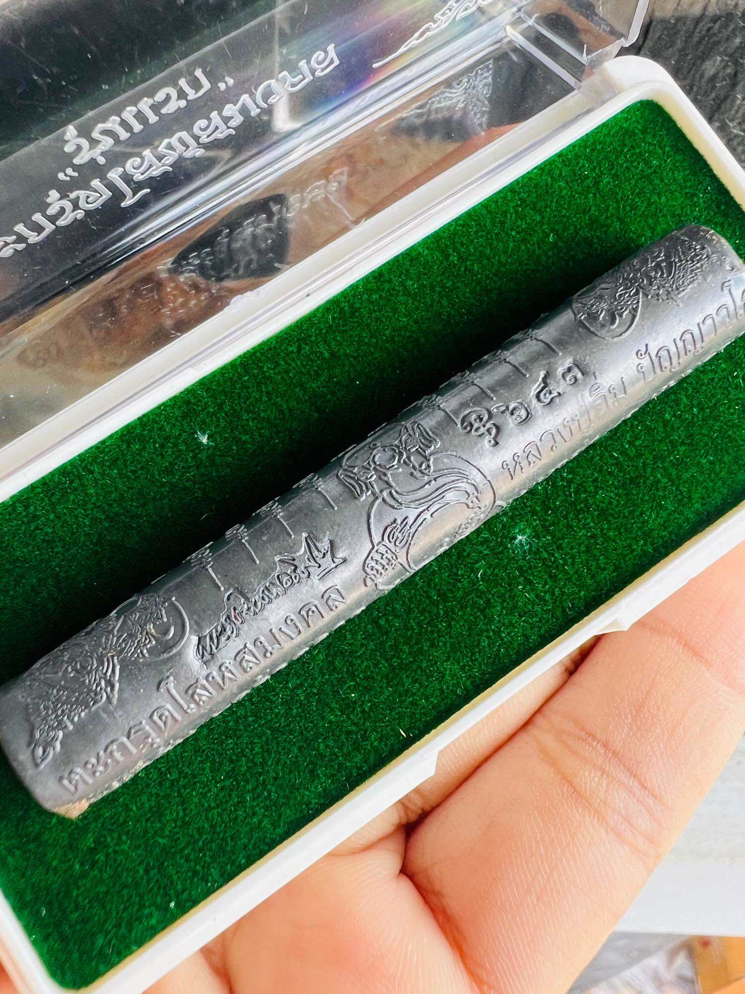 Takrut Solos Mongkol amulet engraved metal scroll in green felt box held in hand Thai Blessing Co