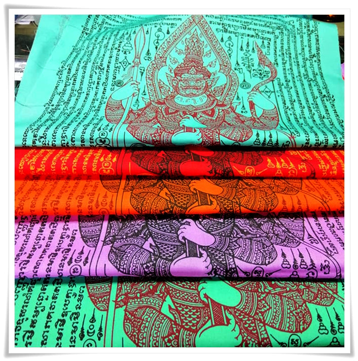 Folded colorful Thao Wessuwan yantra cloth showing guardian deity and Thai script for blessings