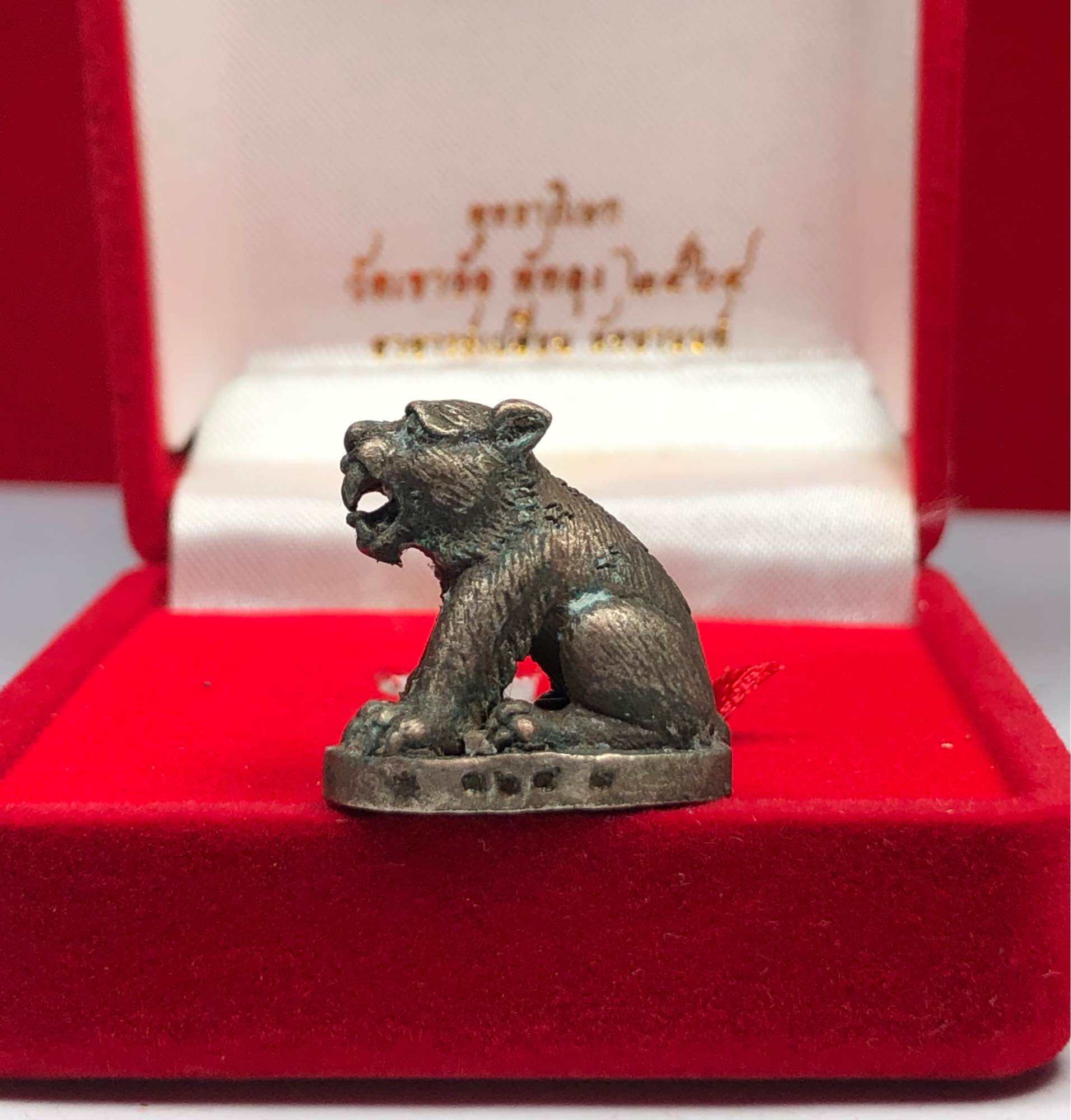 Small bronze Thai tiger amulet for protection figurine displayed in a red velvet box