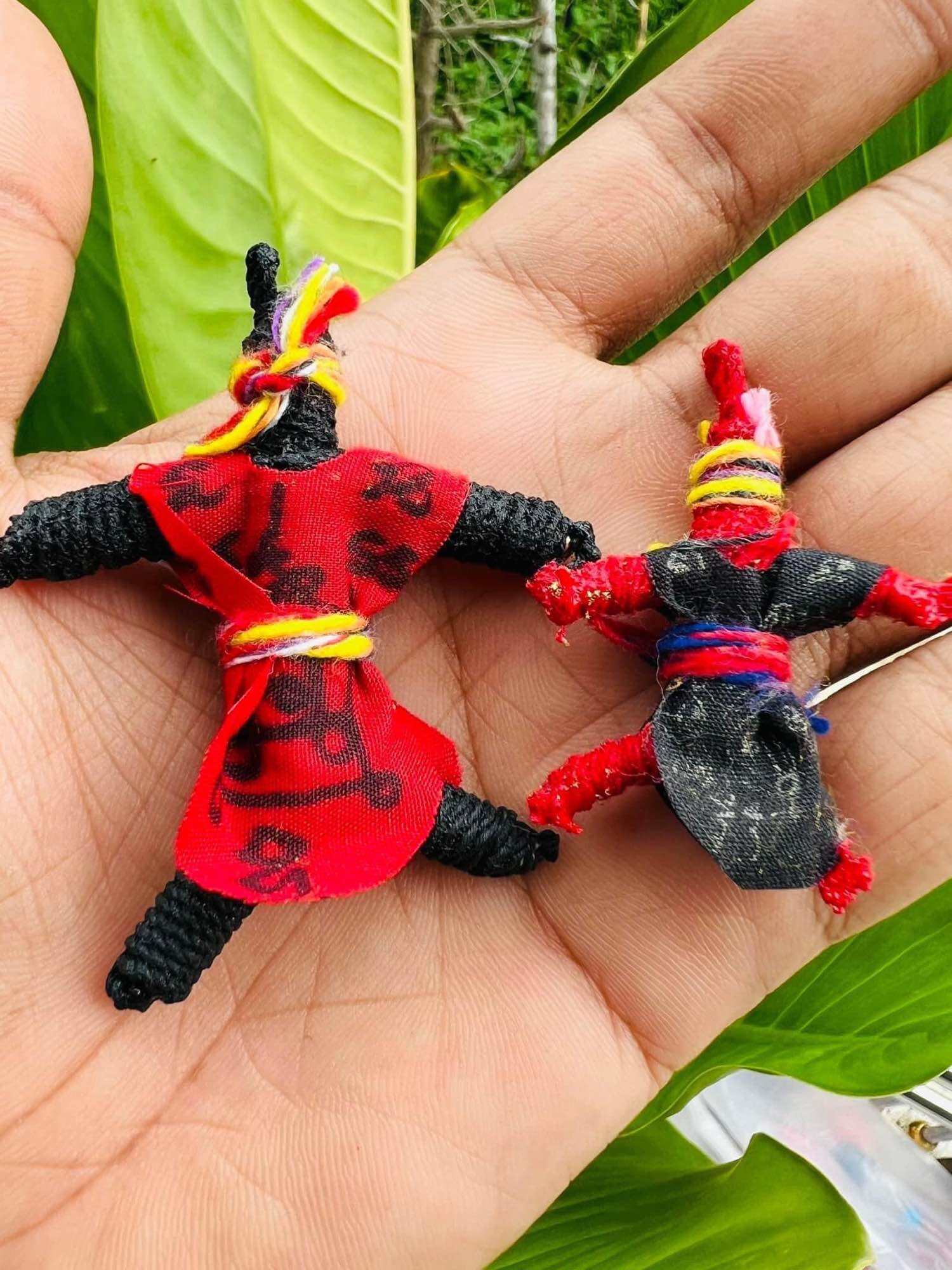 Handheld pair of Hoon Payon amulet dolls Thailand in red and black fabric wrapped with sacred thread by Thai Blessing Co