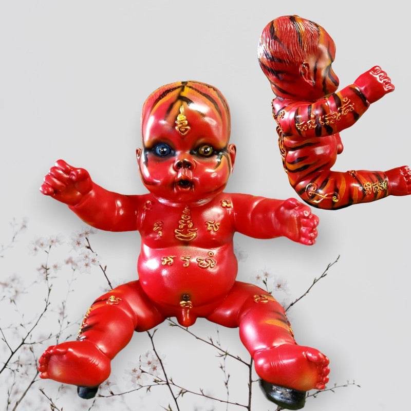 Red Thai wealth and luck charm baby doll with gold script markings for home and religious use