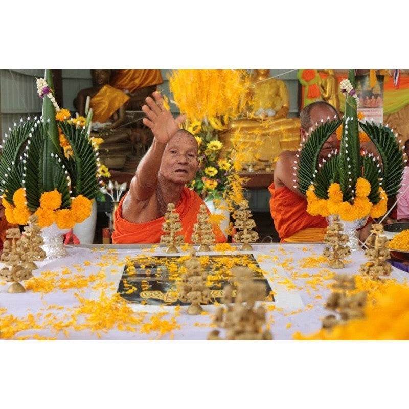 Buddhist monk performing a blessing ritual with Thai wealth pig amulet for prosperity and good fortune