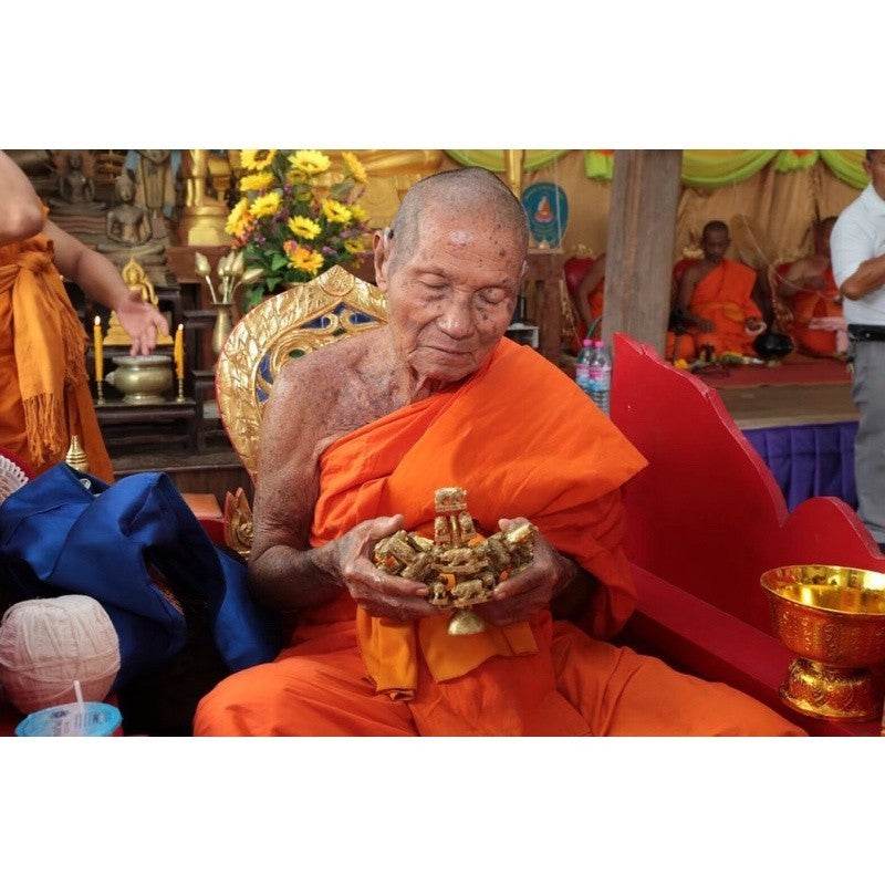 Thai monk blessing a Thai wealth pig amulet for prosperity and good fortune