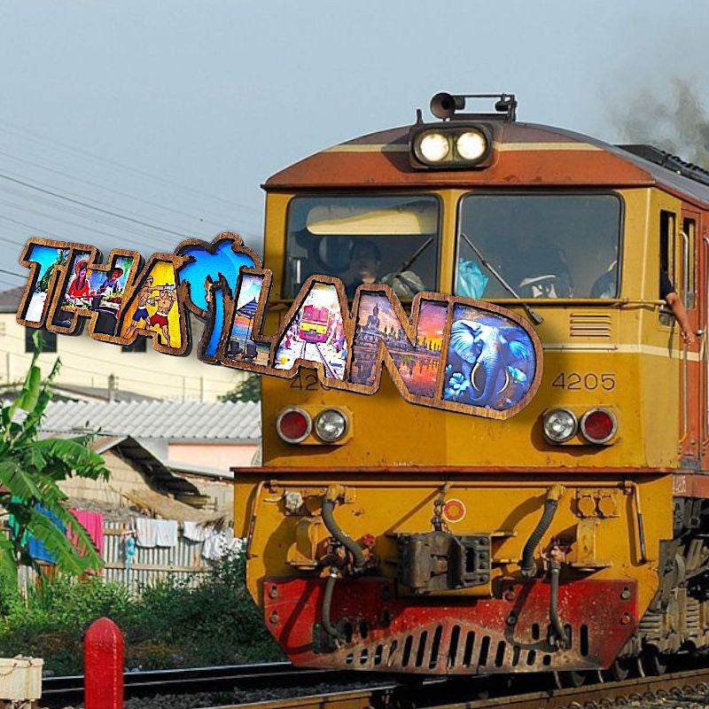 Thai wood magnet souvenir with colorful Thailand design on yellow vintage train in outdoor setting