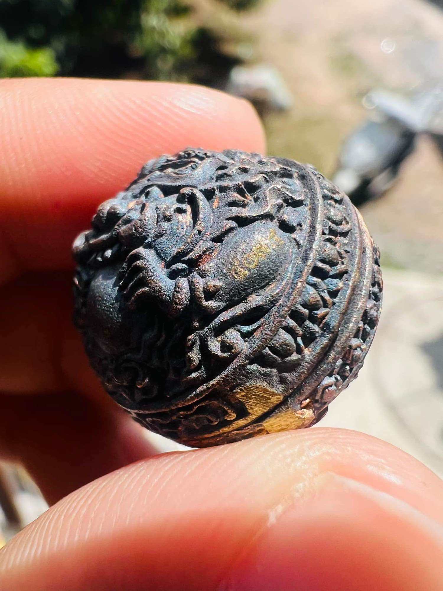Thai Blessing Co ancient Thai talisman first edition small carved bronze amulet sphere with lion motif held between fingers