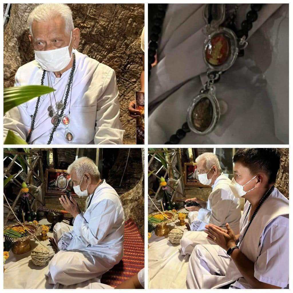 Bia Gae Lord Vaisravana amulet on beaded necklace worn during Thai blessing ritual with seated elder