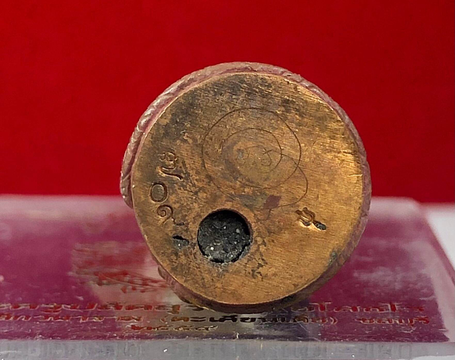 Aged round brass amulet base with engraved yantra and central cavity on clear stand Hanuman Maha Prap Amulet