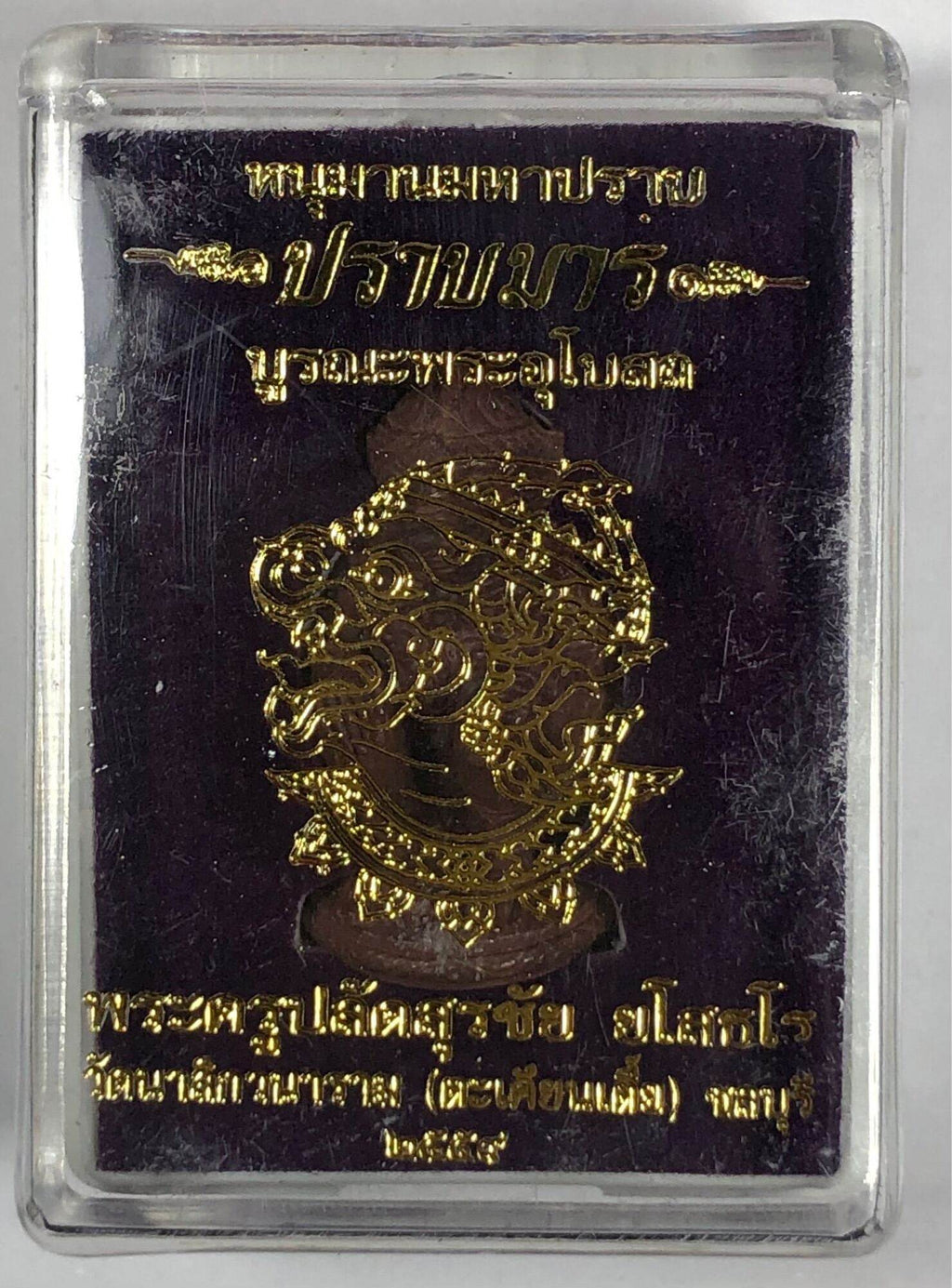Hanuman Maha Prap Amulet gold embossed Hanuman face in clear plastic display case with Thai script