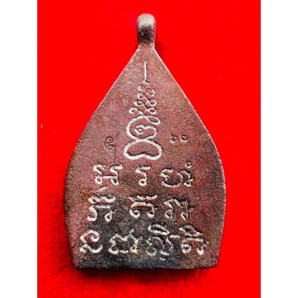 limited edition Thai lucky charm bronze amulet pendant with carved sacred script on red background