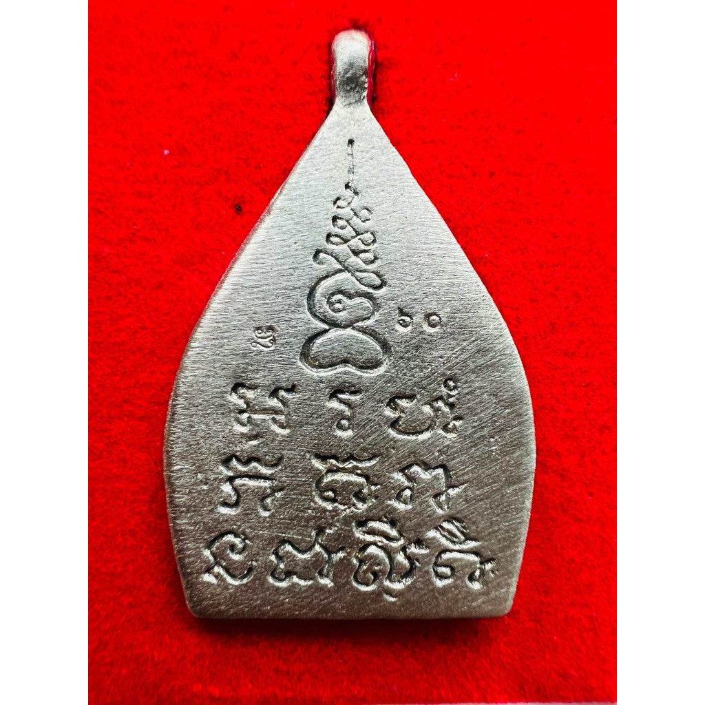 limited edition Thai lucky charm silver metal amulet pendant with Thai script engraving on red background for protection