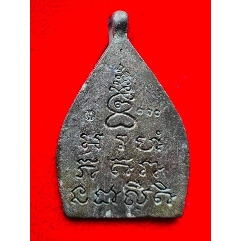 Thai Blessing Co metal teardrop amulet with engraved script and yantra on red cloth limited edition Thai lucky charm