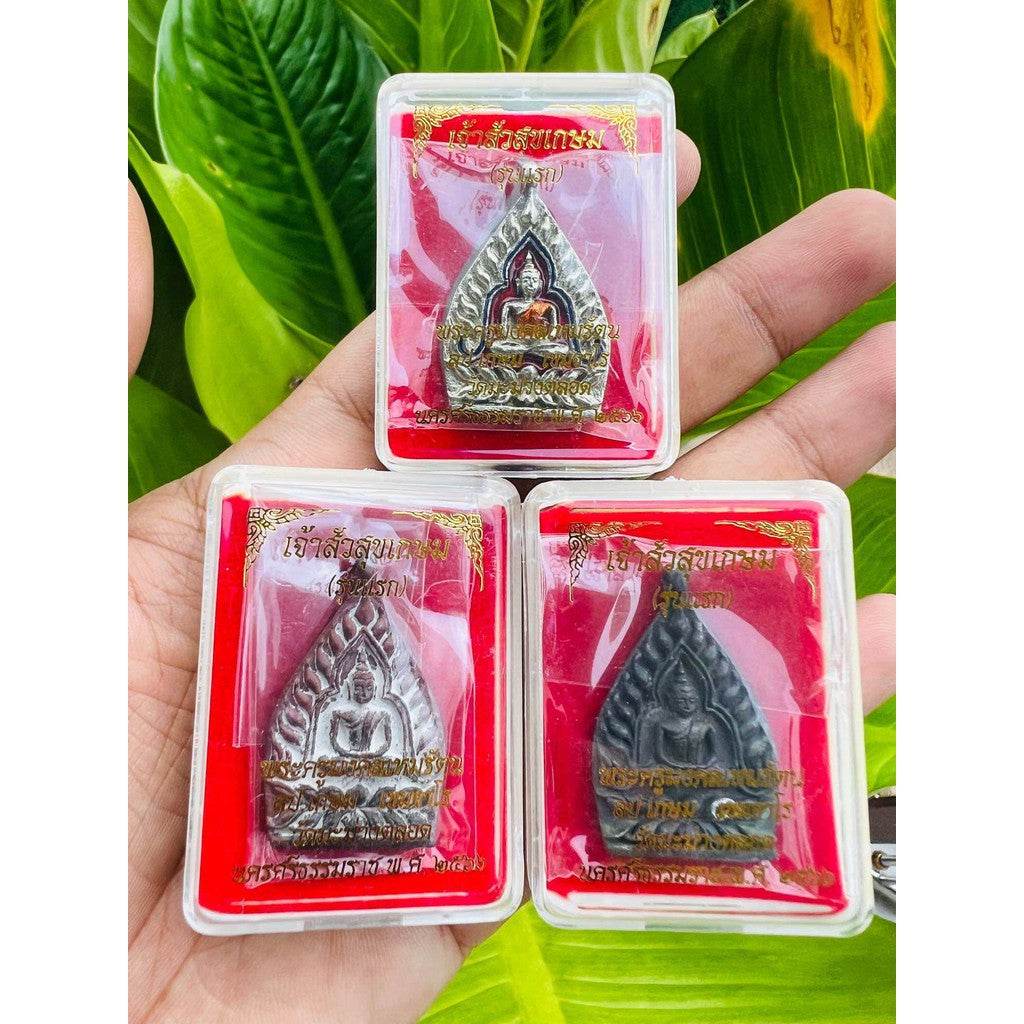Hand holding three packaged Buddhist amulet pendants in red cases by Thai Blessing Co limited edition Thai lucky charm