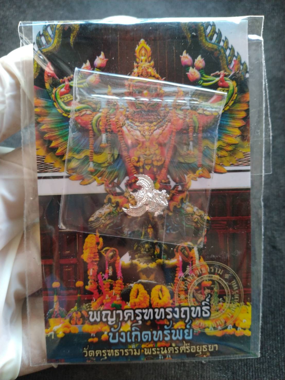 mini Garuda amulet Thailand silver pendant in plastic bag on colorful Garuda shrine card by Thai Blessing Co