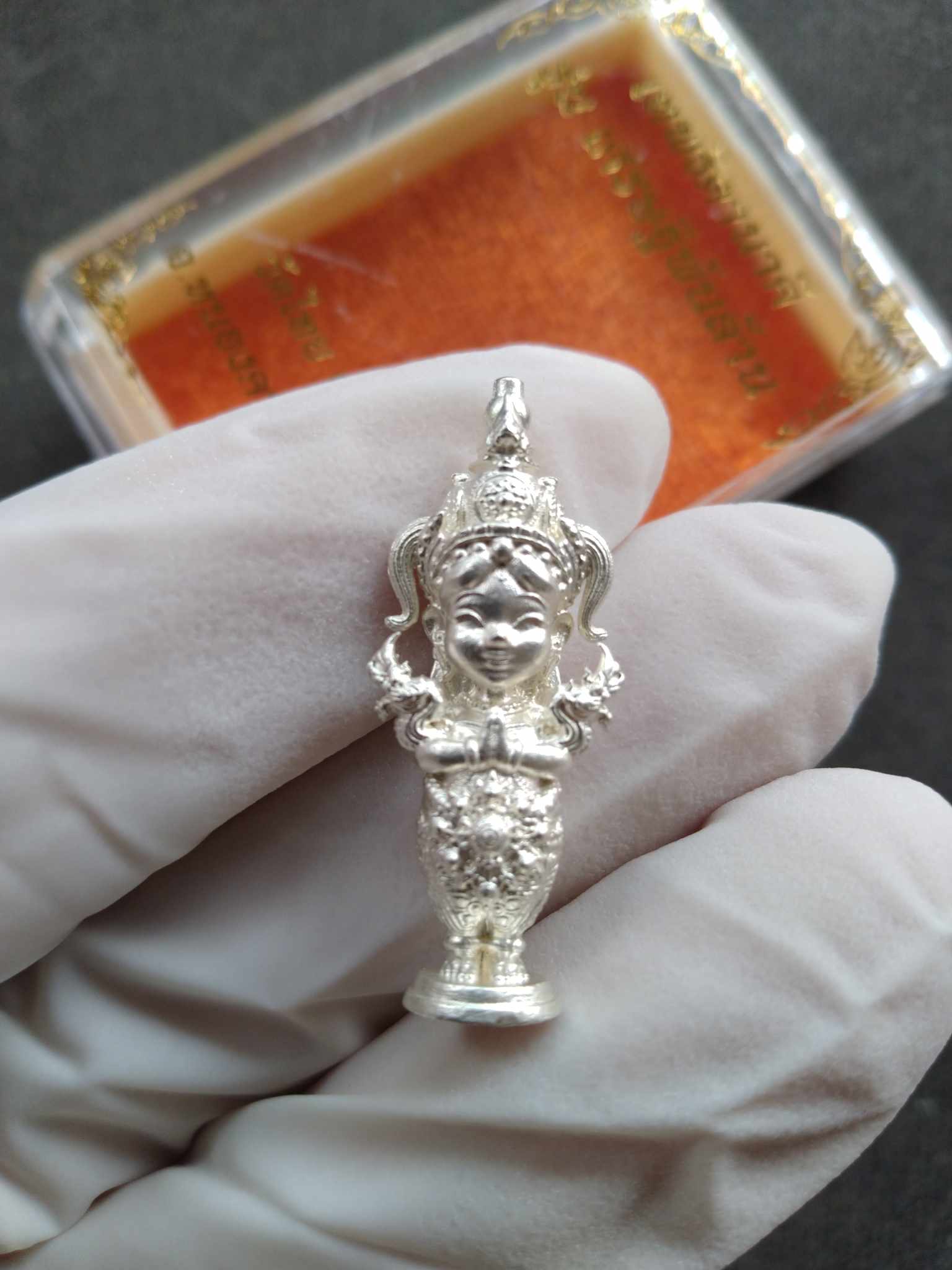 Thai Blessing Co silver Naga Princess Goddess Setthi Phan Lan . miniature ornate pendant amulet held in gloved hand