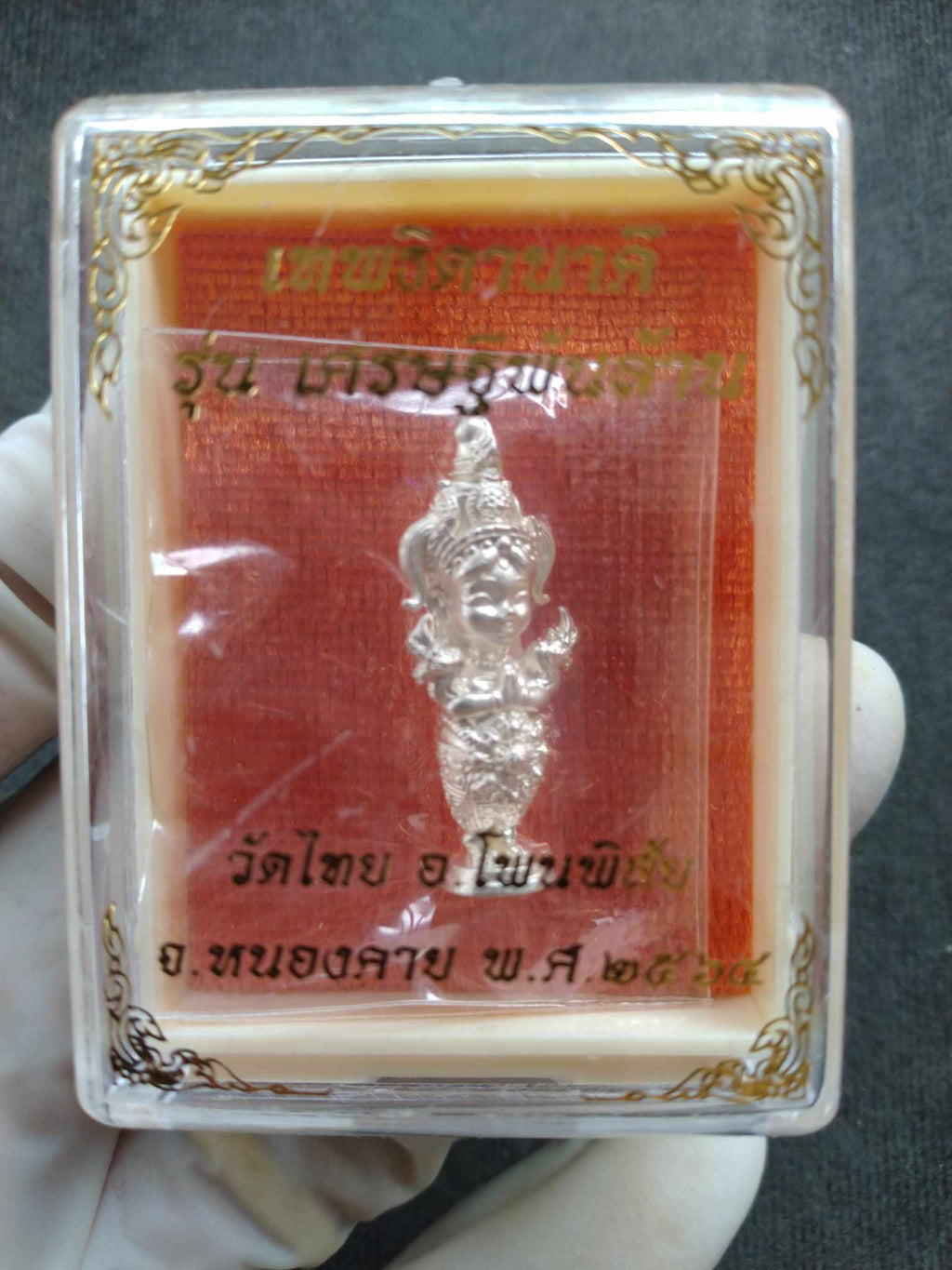 Naga Princess Goddess Setthi Phan Lan silver amulet figurine in clear plastic display case with red gold Thai background