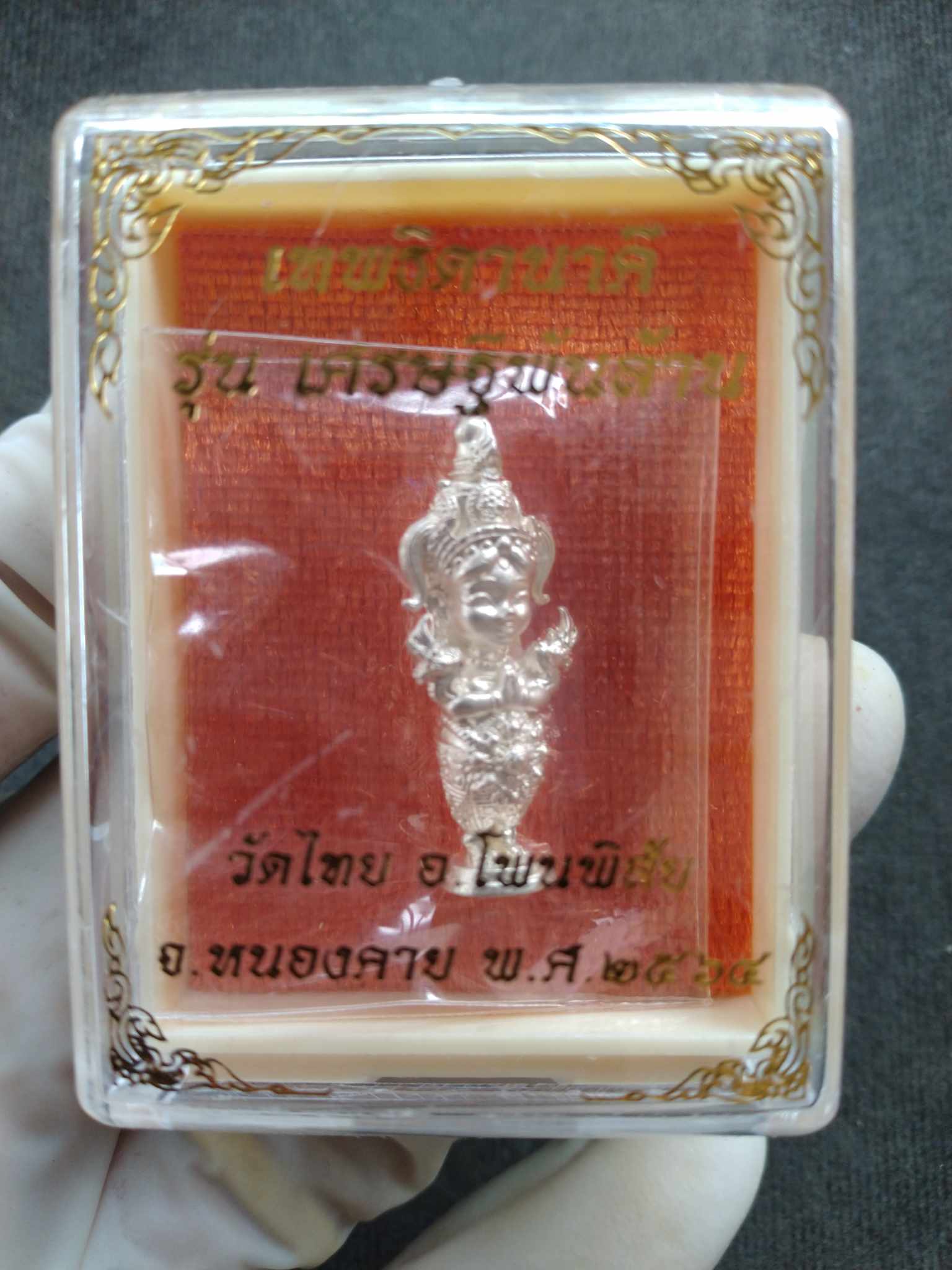 Naga Princess Goddess Setthi Phan Lan silver amulet figurine in clear plastic display case with red gold Thai background