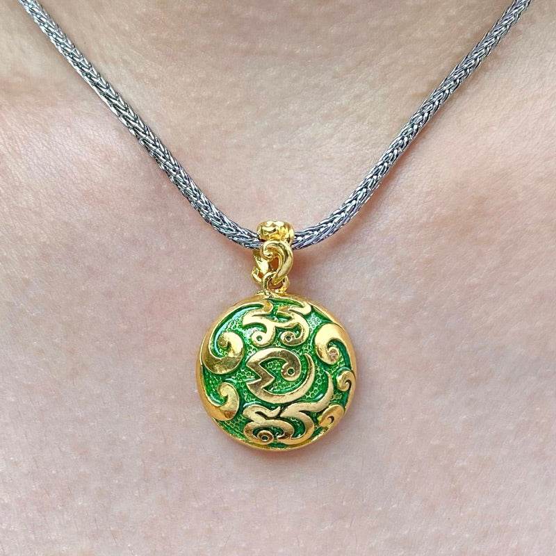 Gold and green enamel pendant on silver chain worn on neck Naga prosperity coin Thailand for good luck