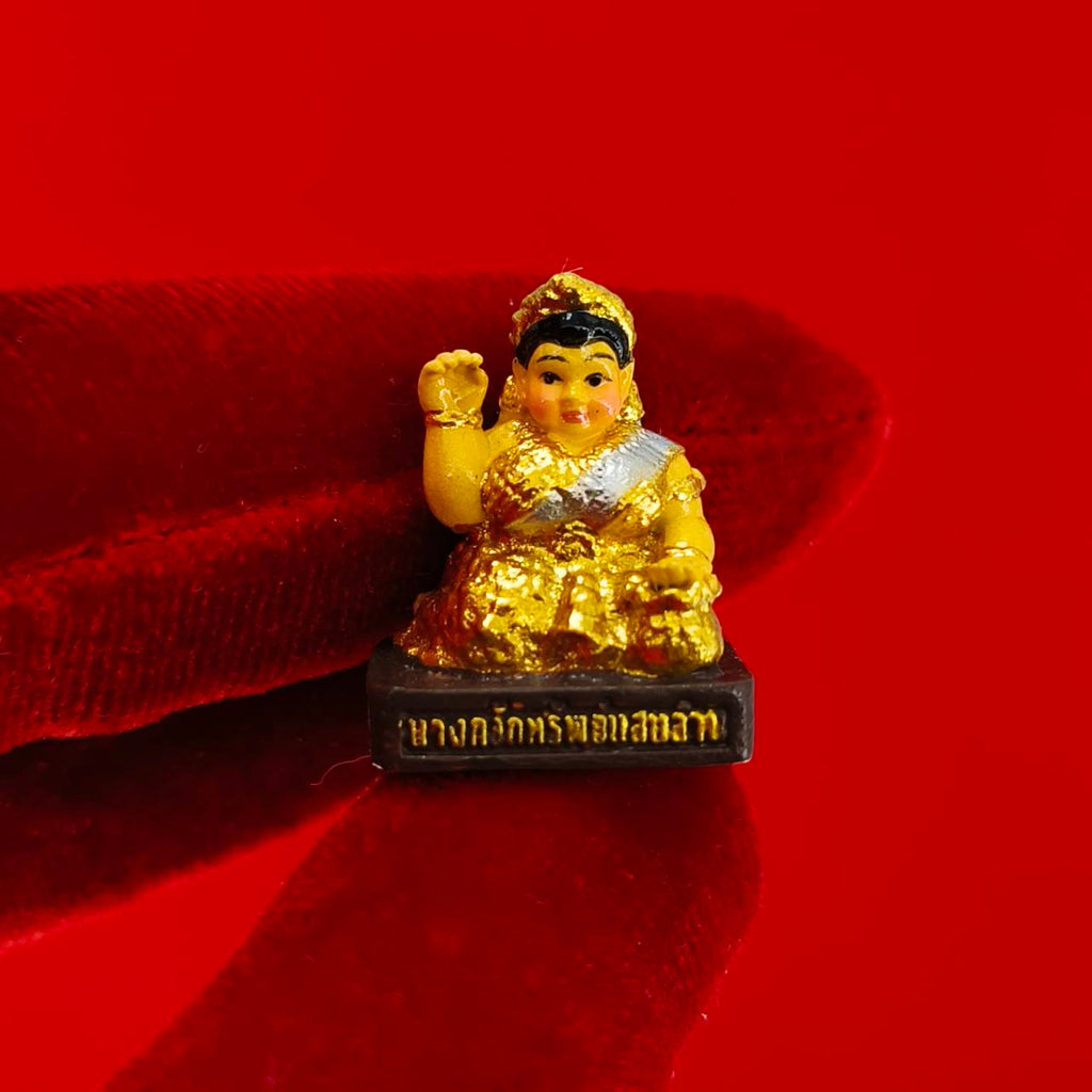 Thai Blessing Co Nang Kwak amulet for wealth small gold painted Thai prosperity figurine on red background